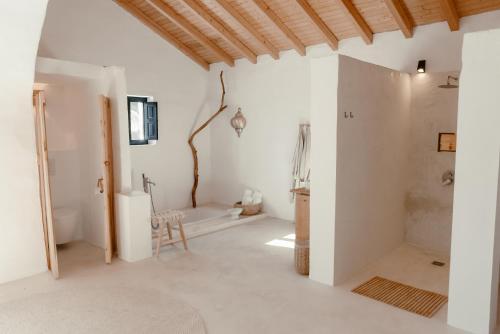 baño con paredes blancas y techo de madera en Finca Elements, en Comares