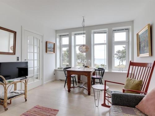 a living room with a table and chairs at Apartment Reinhardt - 100m from the sea in Bornholm by Interhome in Allinge
