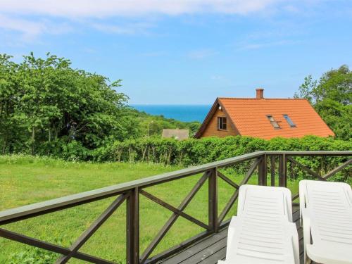 two white chairs on a deck with a house at Holiday Home Dagmar - 300m from the sea in Bornholm by Interhome in Hasle