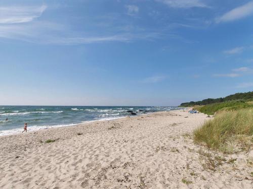 uma praia de areia com pessoas a nadar no oceano em Holiday Home Dorit - 600m from the sea in Bornholm by Interhome em Hasle