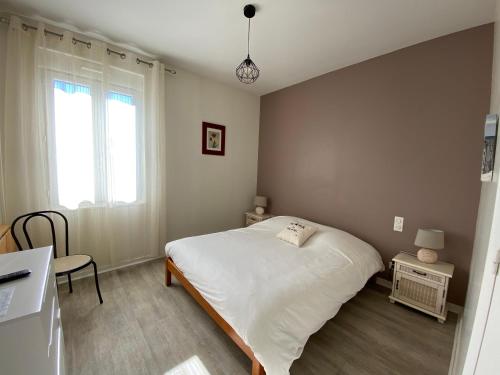1 dormitorio con cama blanca y ventana en Hôtel La Cote d'Argent, en Seignosse