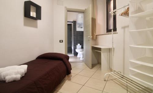 a small room with a bed and a bathroom at I Giganti in Cagliari
