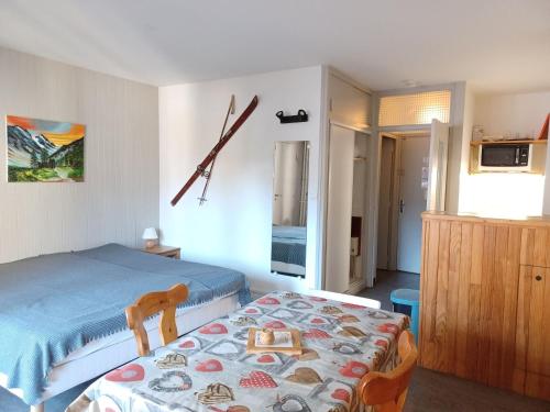 une chambre avec un lit et une horloge au mur dans l'établissement Studio cosy pour 2 au centre de Brides-les-Bains, proche thermes et télécabine - FR-1-512-107, à Brides-les-Bains
