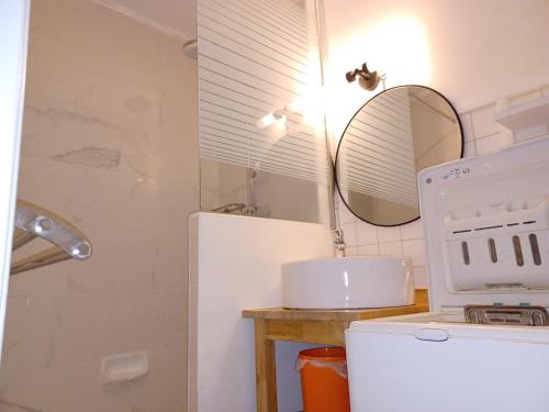 La salle de bains est pourvue d'un réfrigérateur blanc et d'un miroir. dans l'établissement Studio cosy pour 2 au centre de Brides-les-Bains, proche thermes et télécabine - FR-1-512-107, à Brides-les-Bains