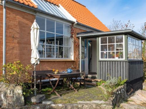 uma pequena casa com uma mesa de piquenique e uma estufa em Holiday Home Inkri - 100m from the sea in Bornholm by Interhome em Allinge