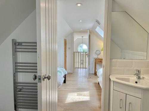 a white bathroom with a sink and a sink at Sea Rose Cottage in Kingsdown