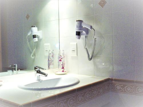 a bathroom with a sink and two phones on the wall at la Maison d'Odette et Daniel in Vitrac