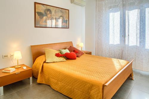 1 dormitorio con 1 cama con sábanas y almohadas de color naranja en Serena House, en Levanto
