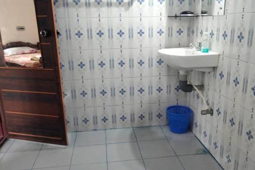 a bathroom with a sink and a toilet and a mirror at Ivy Cottage in Mananthavady