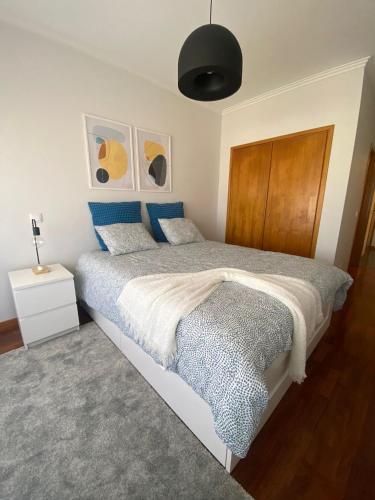 Schlafzimmer mit einem großen Bett mit einem Kopfteil aus Holz in der Unterkunft Apartamento Central in Braga