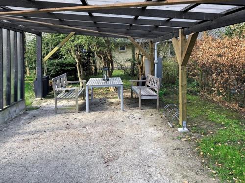 ein Picknicktisch und zwei Stühle unter einer Pergola in der Unterkunft Holiday Home Harald - all inclusive - 300m from the sea by Interhome in Bøtø By