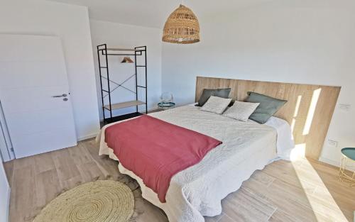een slaapkamer met een groot bed en een rode deken bij Résidence Petra Paolina in Folelli