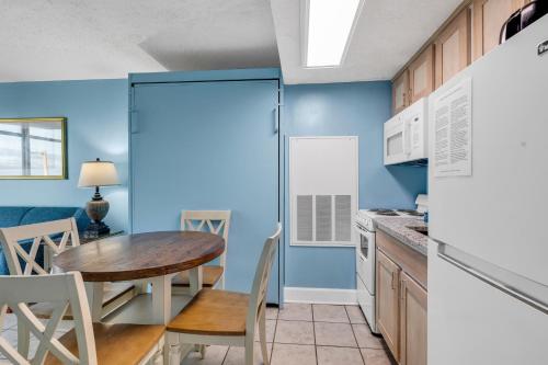 a kitchen with blue walls and a table and chairs at 1BR Beach Condo in Atlantica Resort near Boardwalk in Myrtle Beach
