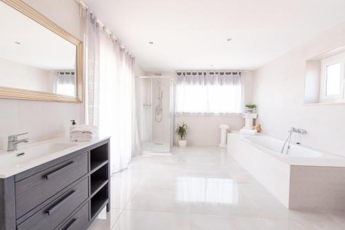 La salle de bains blanche est pourvue d'une baignoire et d'un lavabo. dans l'établissement Luxury 020, à Sant Salvador