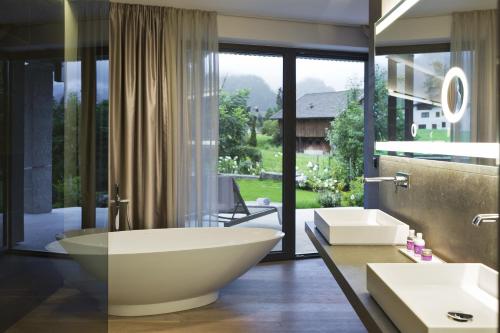 uma casa de banho com uma banheira grande e uma janela grande em ElisabethHotel Premium Private Retreat- Adults only em Mayrhofen