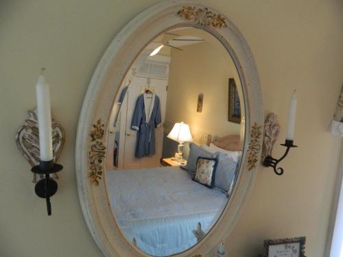 a mirror on a wall with a bed in a room at EJ Bowman House Bed & Breakfast in Lancaster