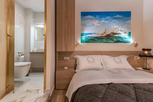 a bedroom with a bed and a painting on the wall at Psyche & Eros Mythical Suites in Athens