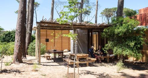 a group of people sitting outside of a cabin at Rizoma in José Ignacio