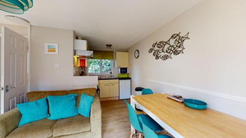 una cucina e una sala da pranzo con un tavolo e un divano di 31 Trevithick Court, Tolroy Manor a Hayle