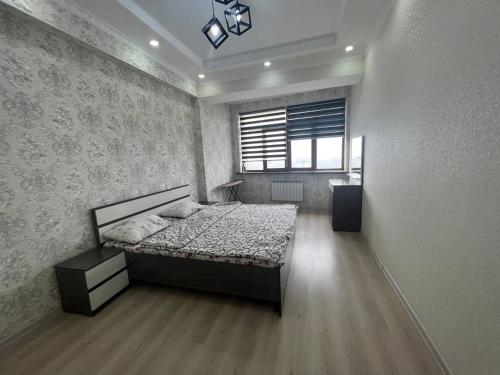 a bedroom with a bed and a window at 3-room apartment on Baytik-Baatyr 37 in Bishkek