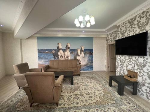 a living room with a painting of horses on the wall at 3-room apartment on Baytik-Baatyr 37 in Bishkek