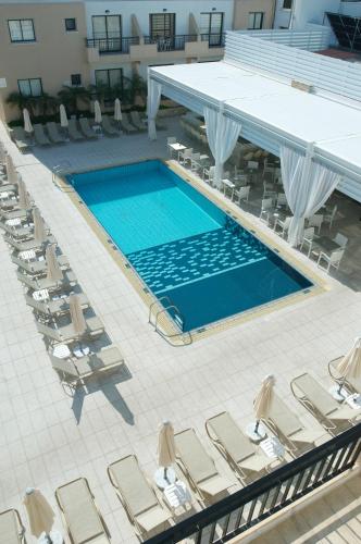 an overhead view of a swimming pool with lounge chairs at Senator Hotel Apartments - Adults Only in Ayia Napa