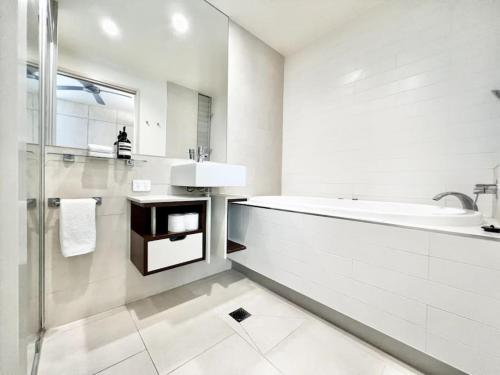 uma casa de banho branca com uma banheira e um lavatório em 7403 Peaceful 5 Star Noosa em Noosa Heads