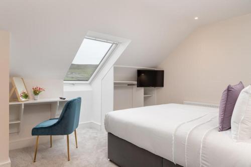 1 dormitorio con cama, escritorio y ventana en The Hawthorn Rooms Dingle en Dingle