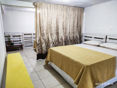 1 dormitorio con cama grande y alfombra amarilla en Casa espaçosa próxima ao centro, en Encantado