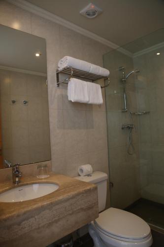 a bathroom with a sink and a toilet and a mirror at Alto del Sol Latorre Mejillones in Mejillones