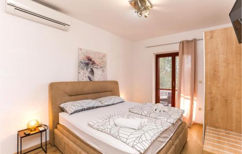 um quarto com uma cama com lençóis brancos e uma janela em Cozy Home In Sv,filip I Jakov With Sauna em Sveti Filip i Jakov