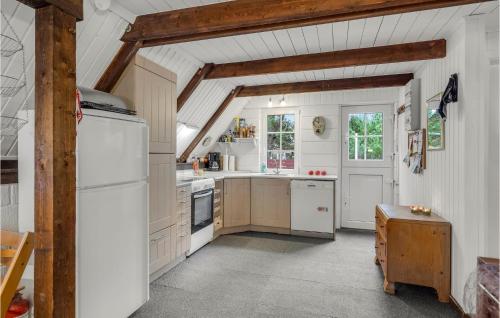 a kitchen with white appliances and a wooden ceiling at Nice Home In Rømø With Wifi in Toftum