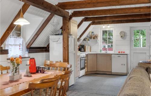 a kitchen with a wooden table and chairs at Nice Home In Rømø With Wifi in Toftum