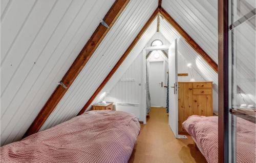 a attic room with two beds and a window at Nice Home In Rømø With Wifi in Toftum