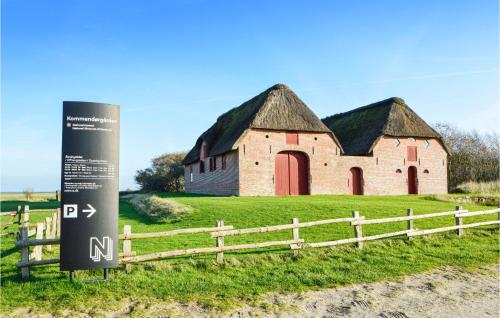 an old barn with a sign next to a fence at Nice Home In Rømø With Wifi in Toftum