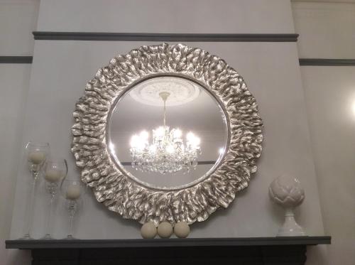 a silver mirror on a wall with a chandelier at Coast B&B in Bexhill