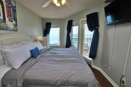 1 dormitorio con 1 cama grande con almohadas azules en Boardwalk 685 en Gulf Shores