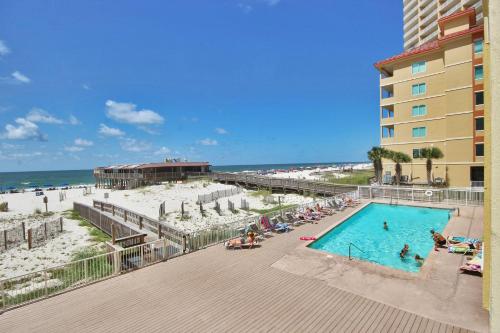 una piscina junto a una playa y un edificio en Boardwalk 685 en Gulf Shores