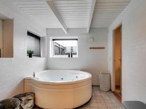 uma grande banheira na casa de banho com uma janela em Holiday Home Hansina - 500m from the sea in Western Jutland by Interhome em Fanø