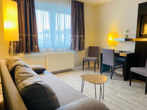 - un salon avec un canapé, une table et un bureau dans l'établissement Hotel 22, à Dessau