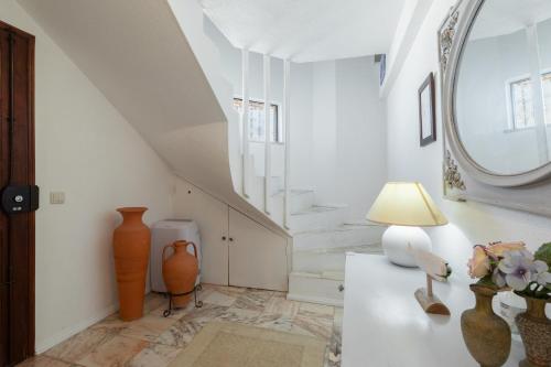 a hallway with a staircase with a mirror and vases at Apartamento Marina in Albufeira