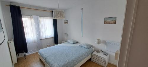 a small bedroom with a bed and a window at Appartement Zeedijk Blankenberge - near Brugge in Blankenberge