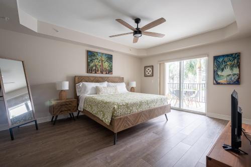 a bedroom with a bed and a ceiling fan at Updated Beach Condo! Facing Heated Pool & Sunset! in Naples