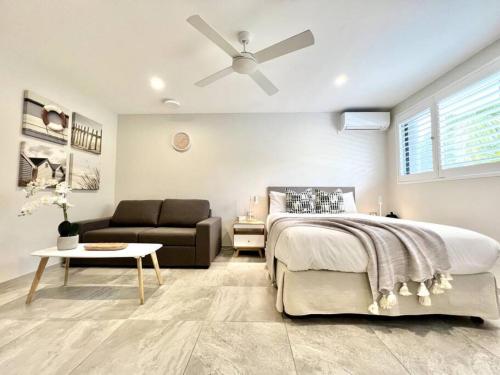a bedroom with a bed and a ceiling fan at 6Stu Hastings Street Studio in Noosa Heads