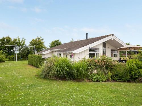 a small white house with a grass yard at Holiday Home Tjakko - 700m from the sea in SE Jutland by Interhome in Neder Lysabild