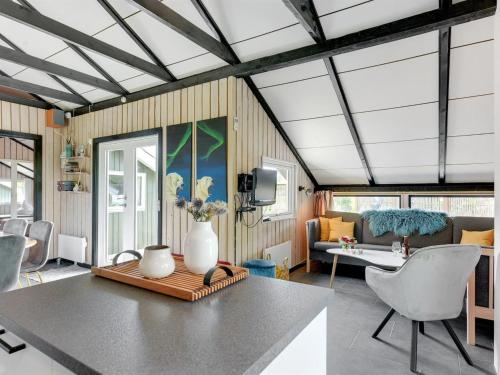 a living room with a couch and a table with a vase at Holiday Home Kolja - 525m from the sea by Interhome in Neder Lysabild