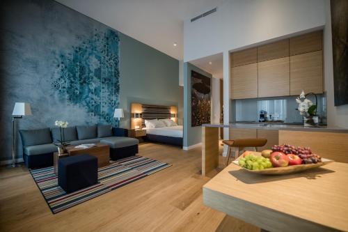 a living room with a couch and a table with a bowl of fruit at The Wellem, in The Unbound Collection by Hyatt in Düsseldorf