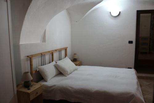 a bedroom with a white bed with an arched ceiling at Casa Griot in Pragelato