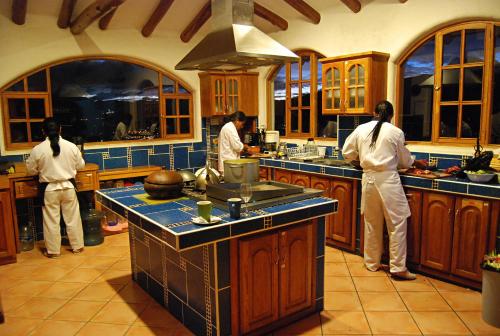 three men standing in a kitchen preparing food at INTIYAYA - Boutique Lodge in Otavalo