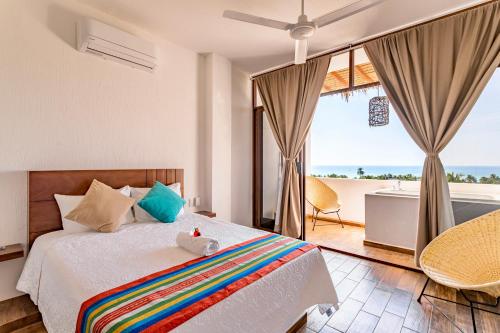 a bedroom with a bed with a view of the ocean at Punta Kai Hotel & Hostal in Puerto Escondido